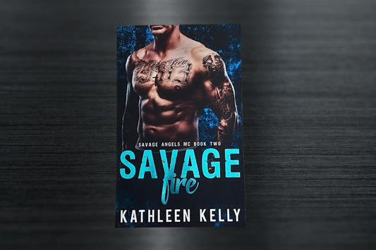 A signed paperback book titled 'Savage Fire - Book 2 Special Edition' with a foiled teal title on the cover.
